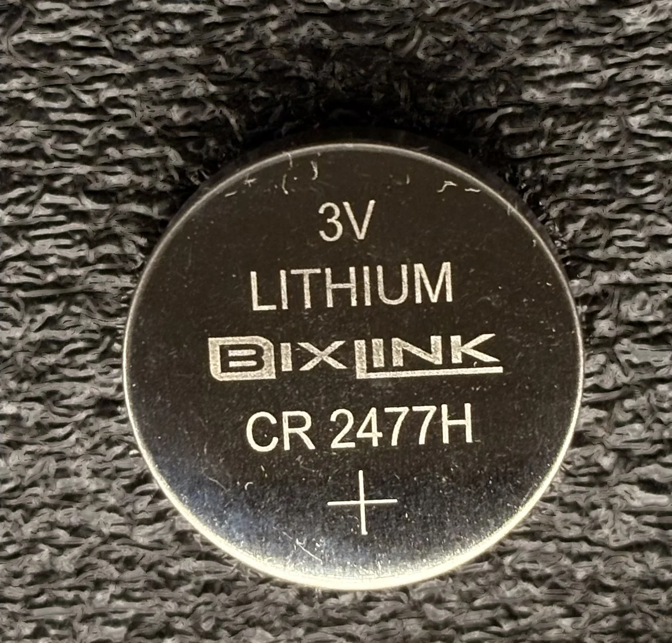 CR2477H coin cell, held in hand